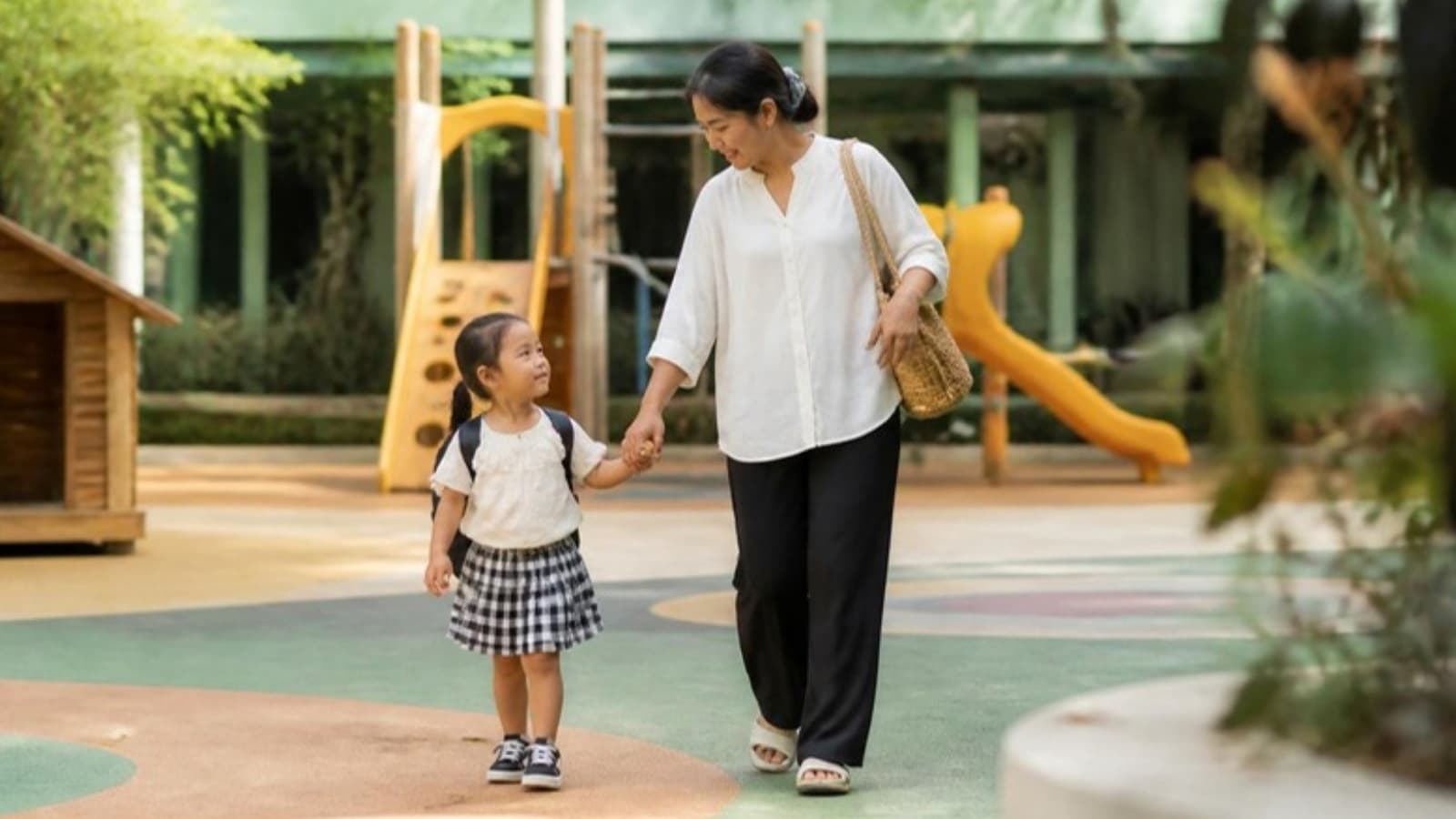 A mother and child walking through an outdoor playground at a CORDA-certified centre